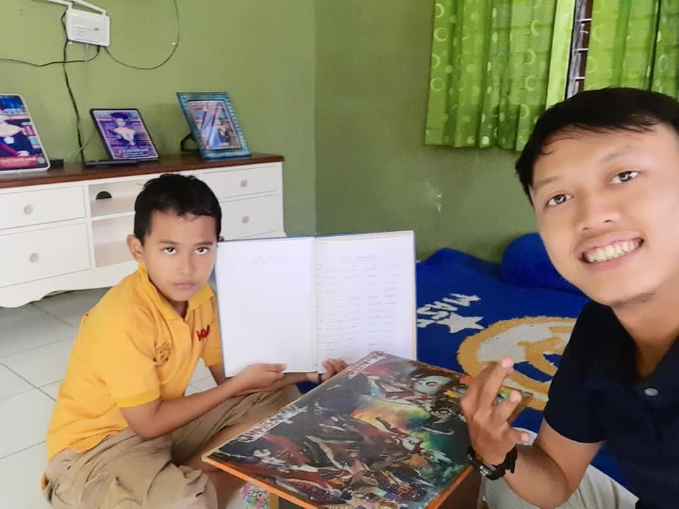 Siswa SD belajar membaca buku bahasa Inggris bersama tutor