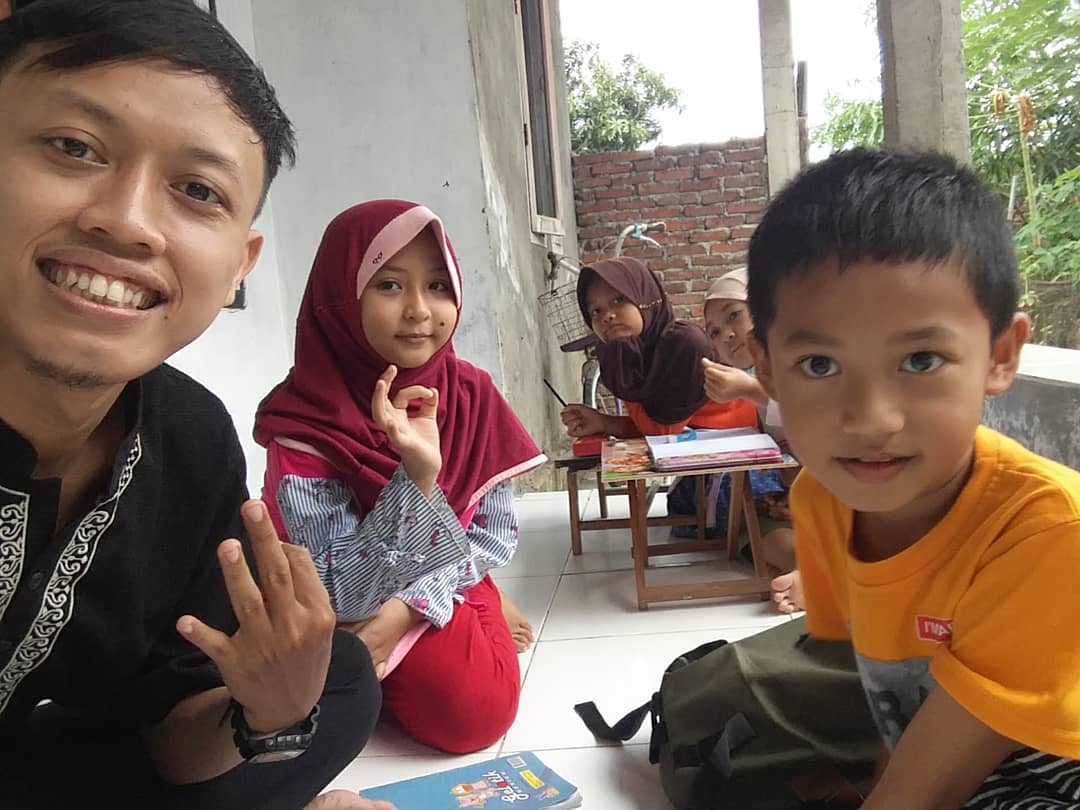 Anak-anak mengikuti kelas grup bahasa Inggris di teras rumah